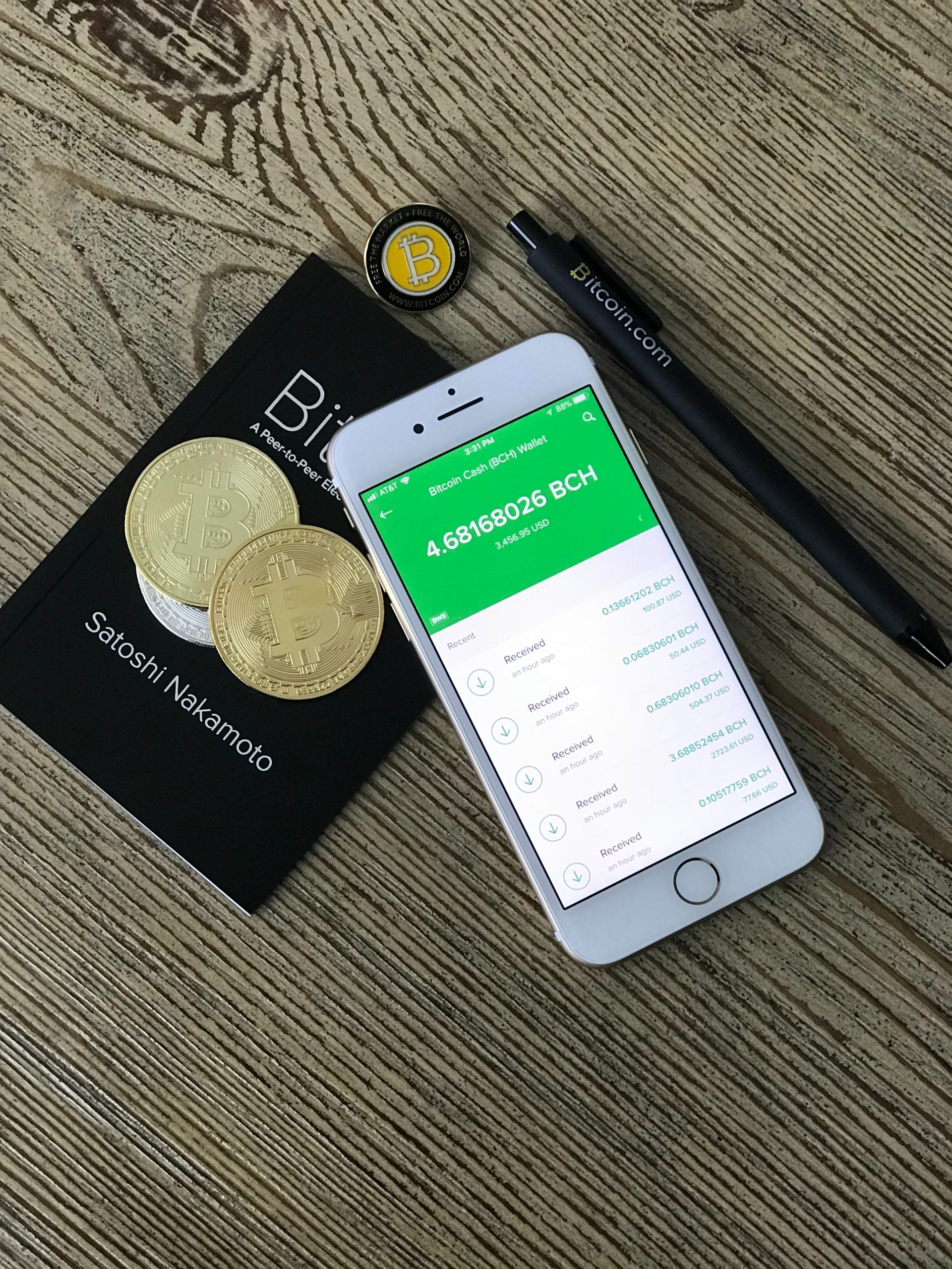 paying with bitcoin silver iPhone 6 beside two coins