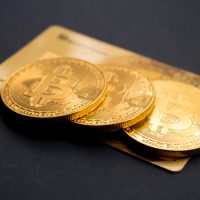 bitcoin investment three round gold-colored Bitcoin tokens