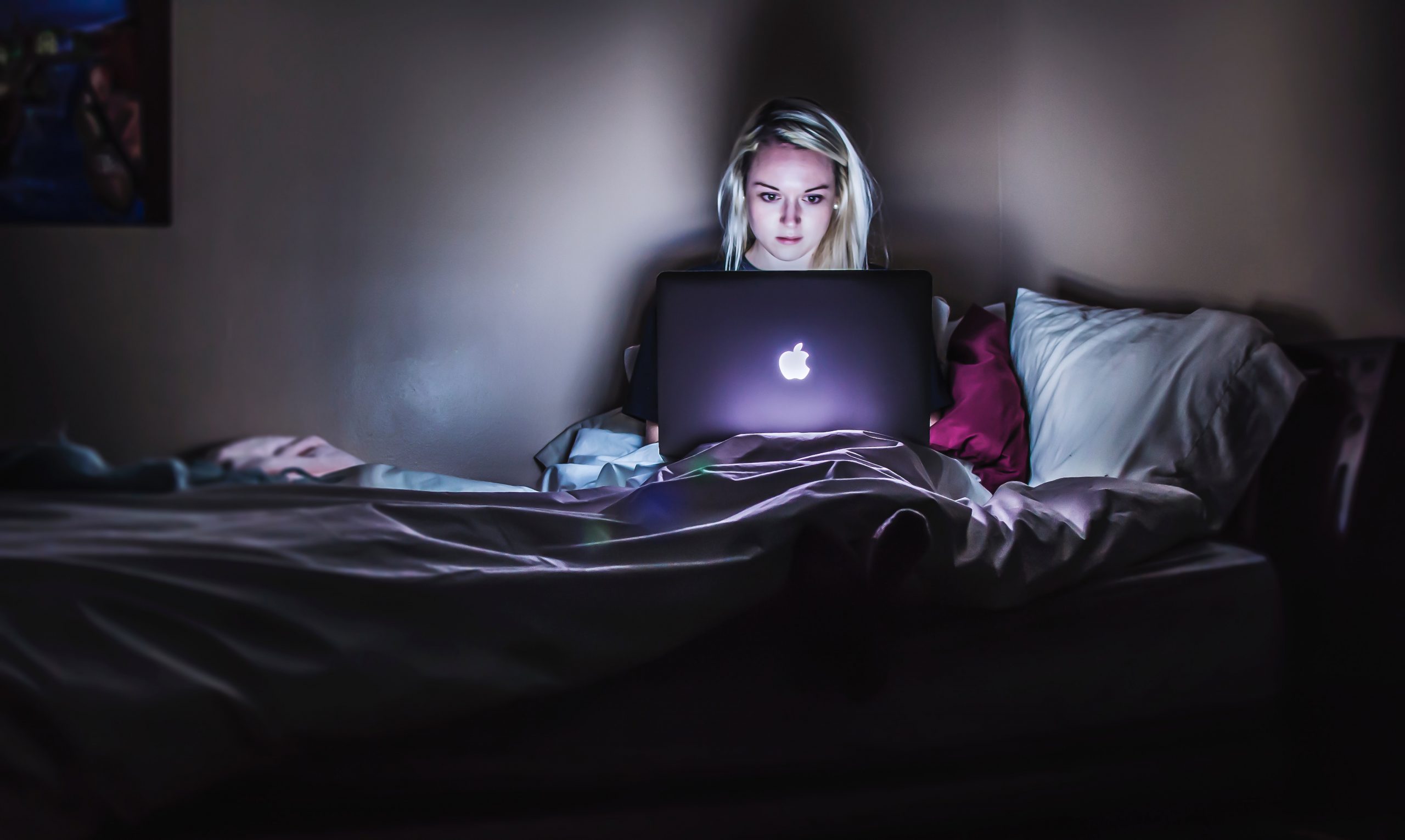 browser extensions Protect Your Privacy Online woman sitting on bed with MacBook on lap