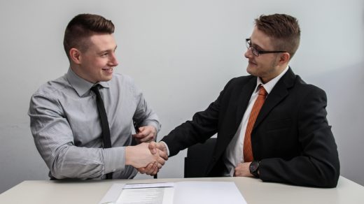 Business Consulting Partner two men facing each other while shake hands and smiling