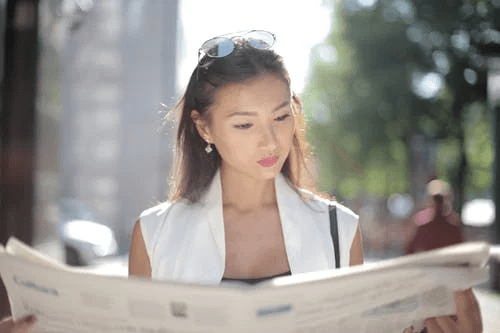 woman reading news Real Estate Agents