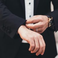 Guide for Entrepreneurs A man's hands adjusting the cuffs of his black suit