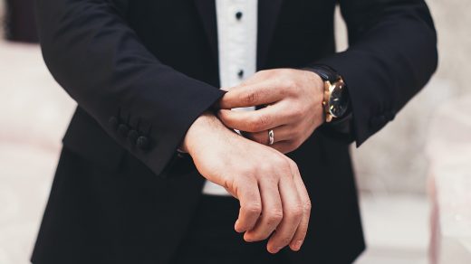 Guide for Entrepreneurs A man's hands adjusting the cuffs of his black suit