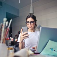 CRM woman in white shirt using smartphone