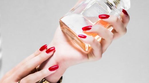perfume person holding clear glass bottle