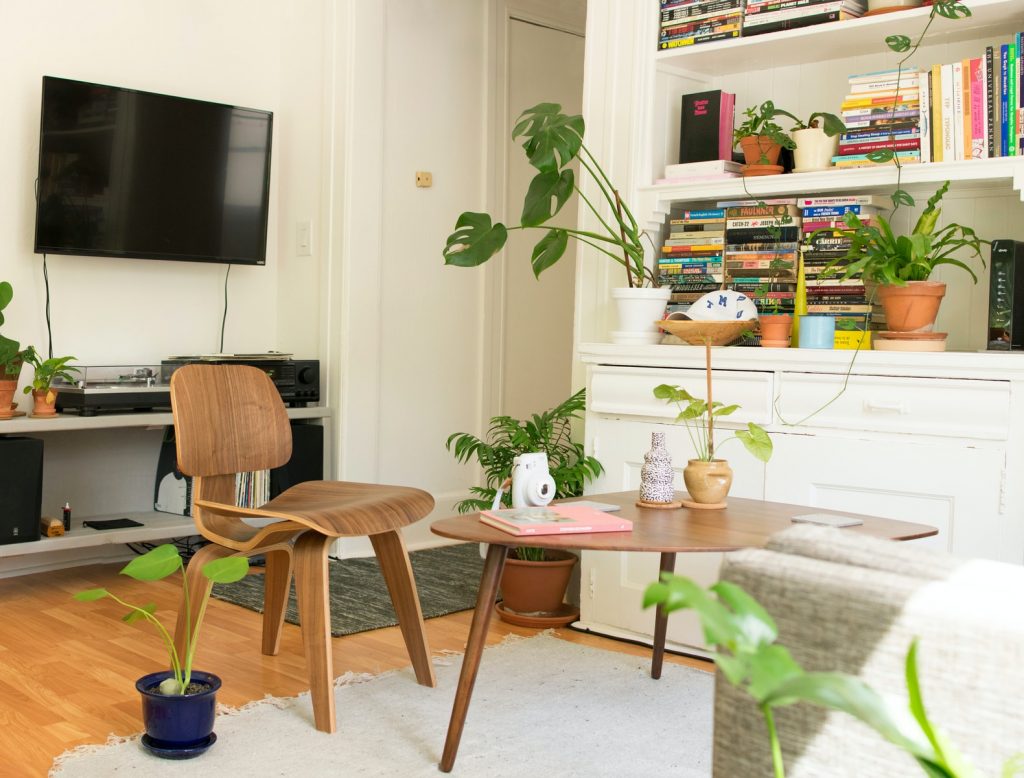 renting an apartment - brown wooden table and chair beside bookshelf