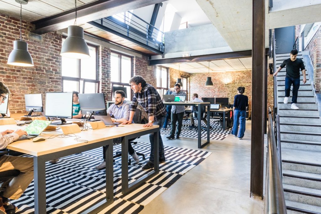 renovate your workplace man standing beside another sitting man using computer