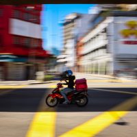 Starting a Delivery Service man in red jacket riding motorcycle on road during daytime