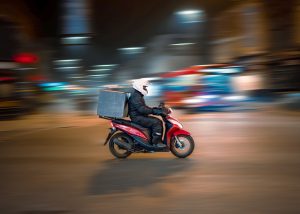 delivery business model man riding motorcycle on road during daytime