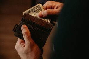 payday loans person getting 1 U.S. dollar banknote in wallet