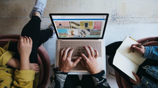 marketing mix person using microsoft surface laptop on lap with two other people