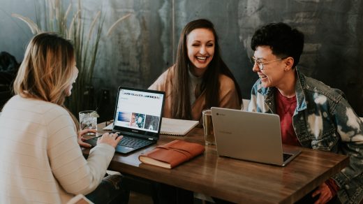 startup - three people sitting in front of table laughing together