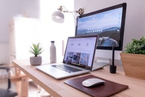 Optimize Your Website MacBook Pro on table beside white iMac and Magic Mouse