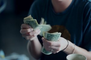 Personal Finance focus photography of person counting dollar banknotes