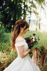woman wearing white off-shoulder wedding gown wearing white petaled flower