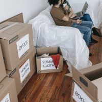 Couple Sitting On A Couch Near Brown Boxes