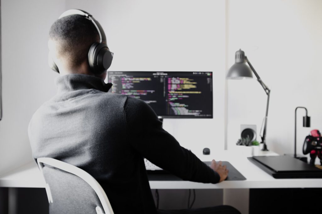 Why should a business hire dedicated developers for their Project? 1 man in black long sleeve shirt wearing black headphones sitting on chair