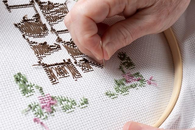 Person doing embroidery using a small needle