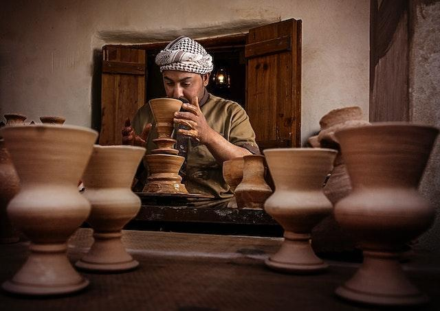 A man doing his pottery in a home shop. 