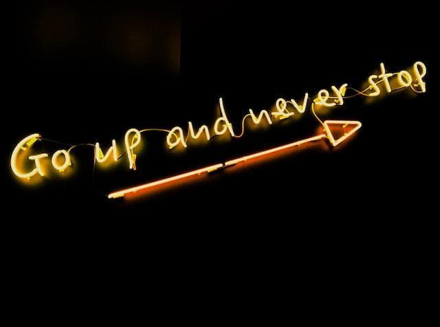 “Go up and never stop” neon sign 