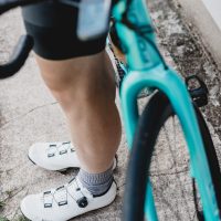 person in white nike sneakers riding on bicycle