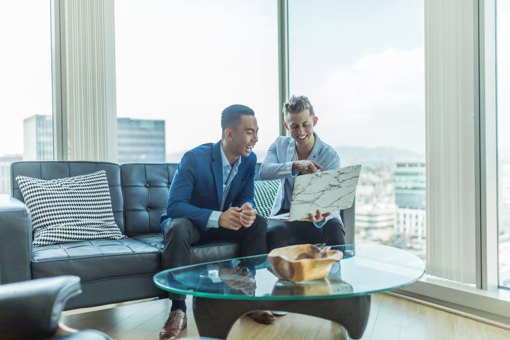 two guys sitting with a laptop