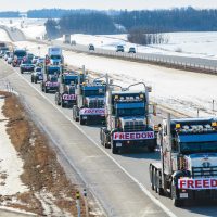 a long line of trucks driving down a highway