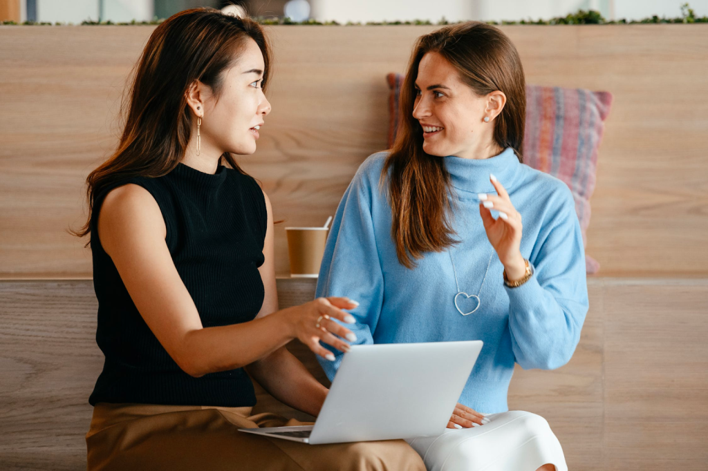 businesswomen with laptop talking