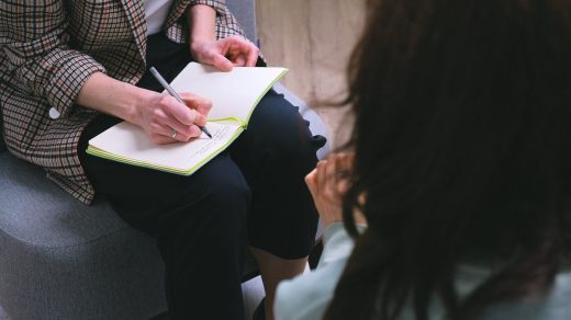 Crop counselor writing in diary while talking to patient