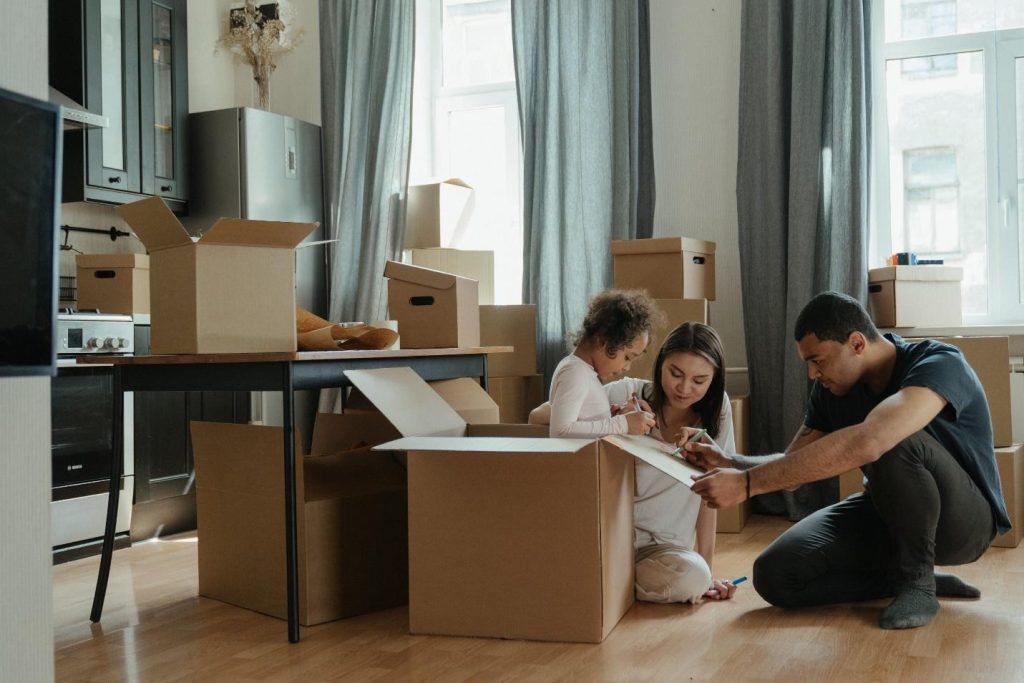 A family unpacking boxes in a room.