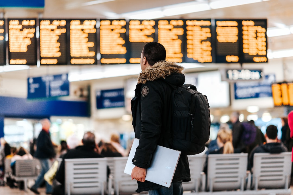 Key Things You Should Know About Taxes When Working Abroad 2 man standing inside airport looking at led flight schedule bulletin board