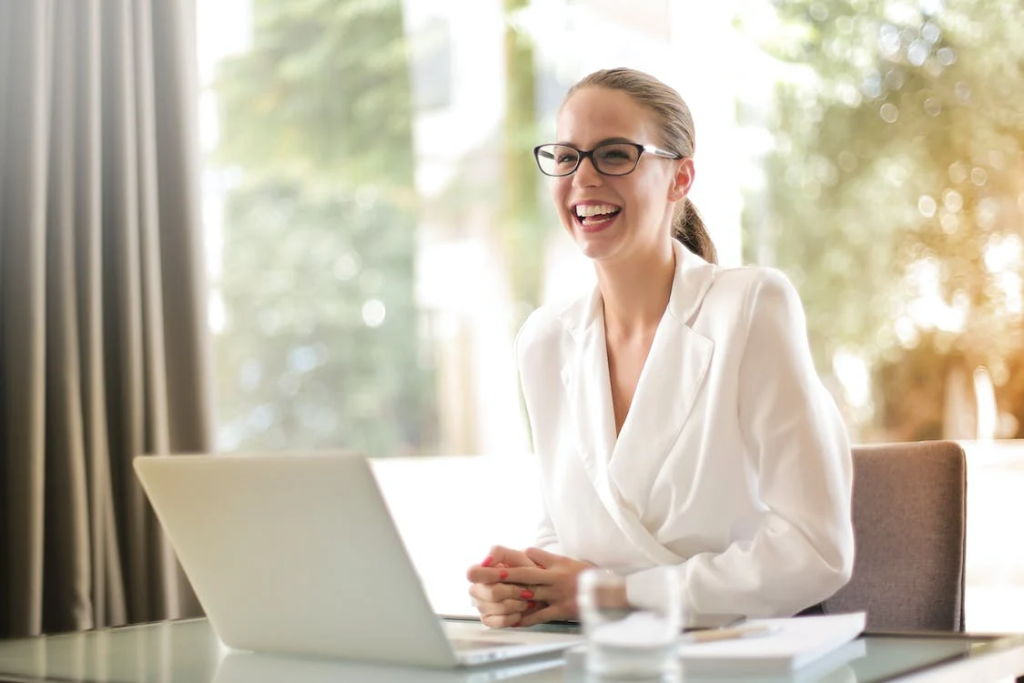 laughing businesswoman working in office with laptop