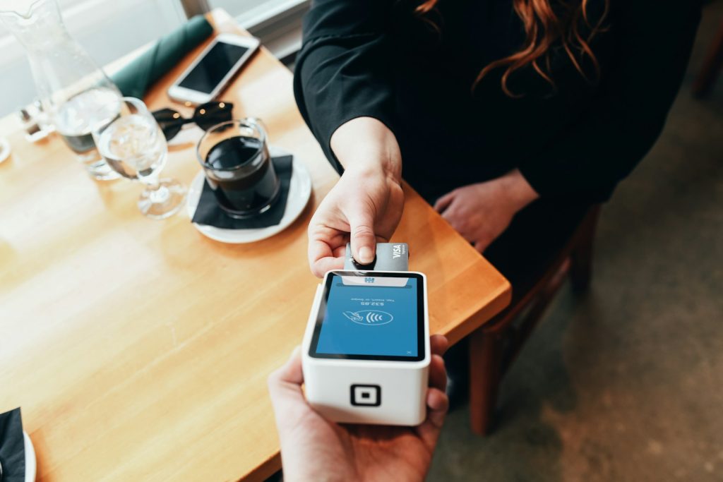 7 Things That You Should NOT Do When Shopping Online with Your Credit Card 1 person holding credit card swipe machine