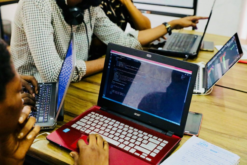 Software Development Companies- person using black and red Acer laptop computer on table